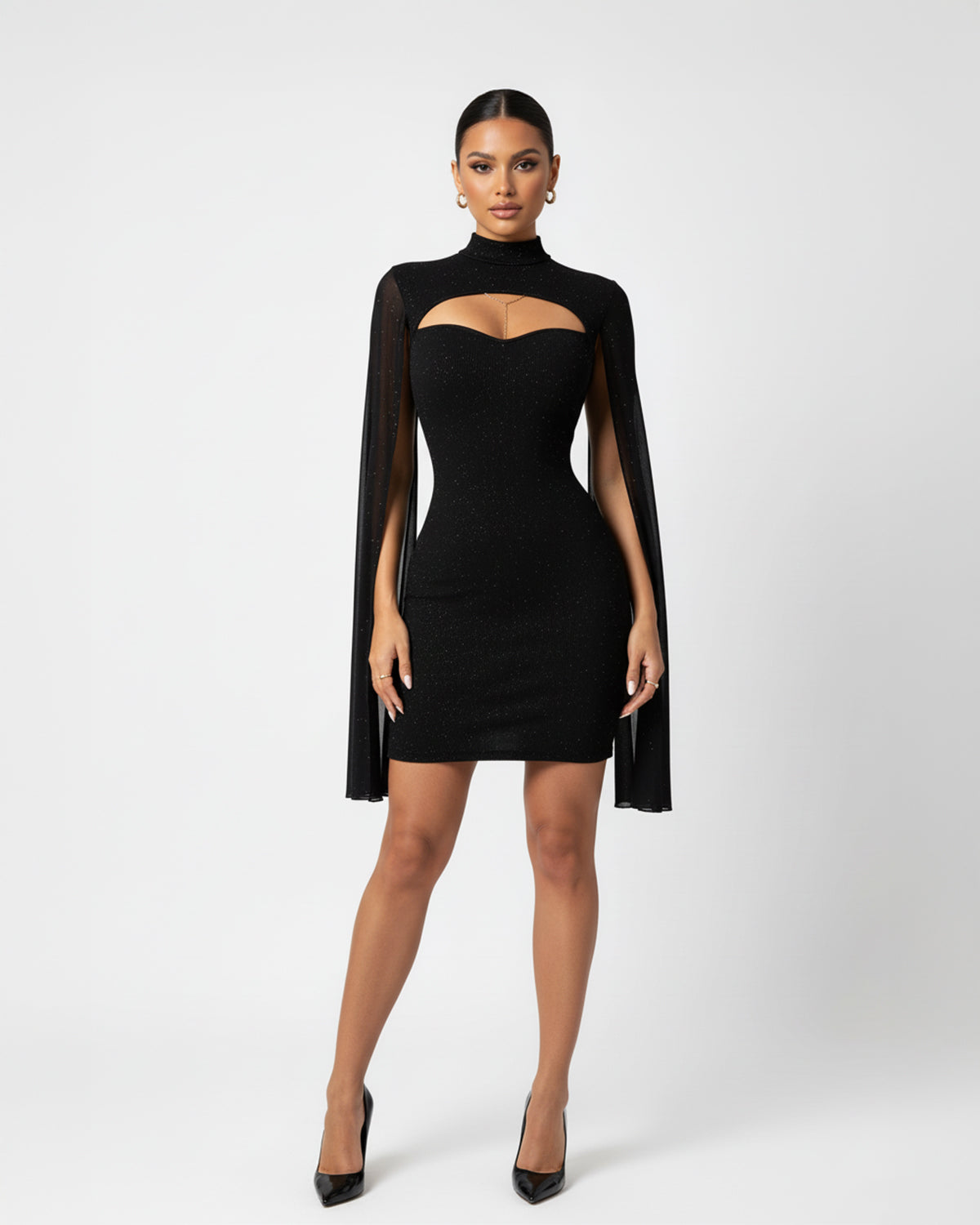 Woman wearing a black dress with cape on a white background