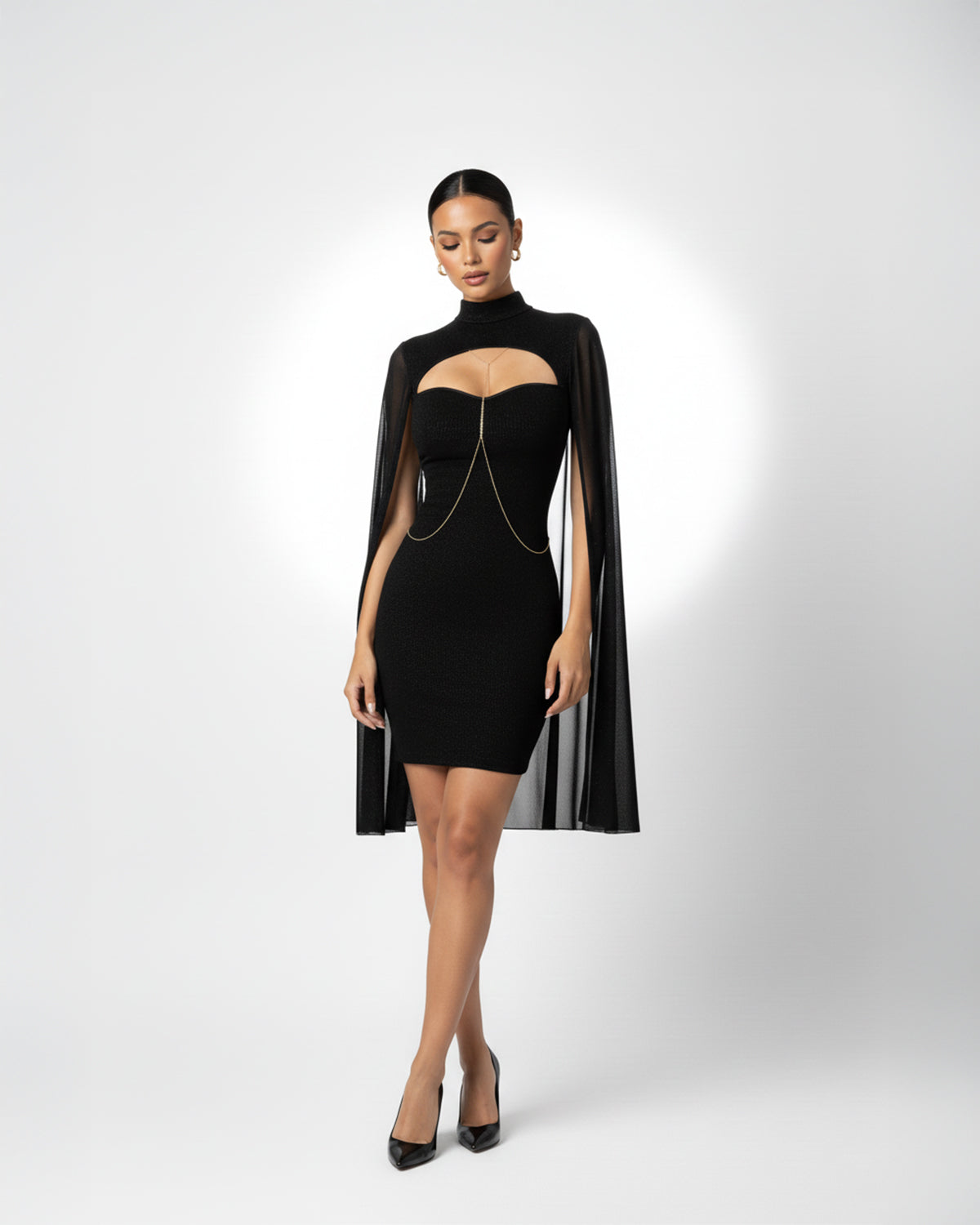 Woman wearing a black dress with cape on a white background