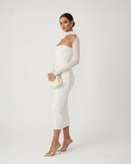 Woman wearing a white off-shoulder dress against a plain background