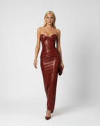 Woman wearing a strapless brown leather dress on a white background